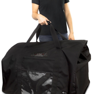 A woman holding a large black bag with a dog inside.