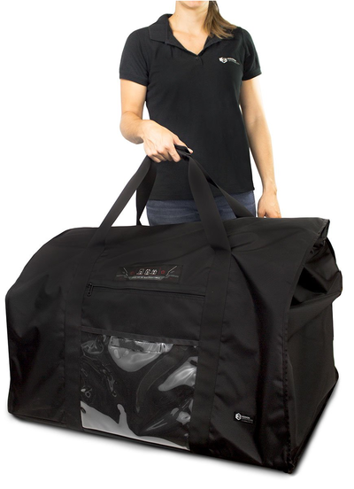 A woman holding a large black bag with a dog inside.